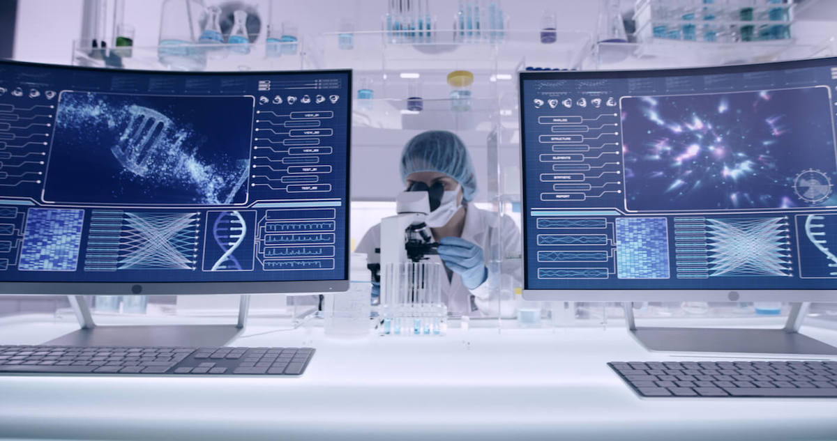 A scientist in protective gear works in a futuristic laboratory filled with advanced equipment. Two large monitors display DNA sequences and cosmic patterns, surrounded by various lab instruments and test tubes.